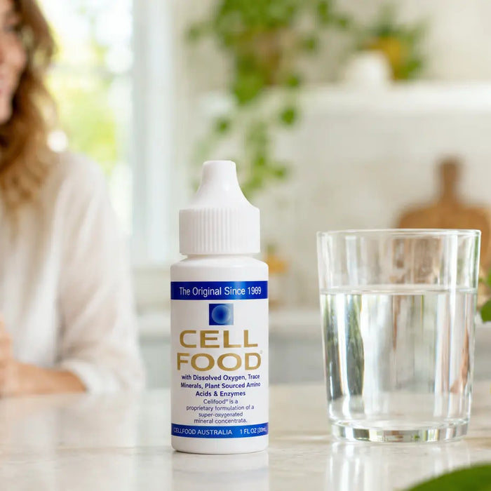 Cell Food drops beside a glass of water for a daily wellness and hydration routine