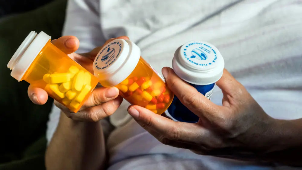 Unbranded 5-HTP supplement bottle beside prescription medicine packaging and an information leaflet, illustrating the importance of checking medication interactions before choosing a supplement.