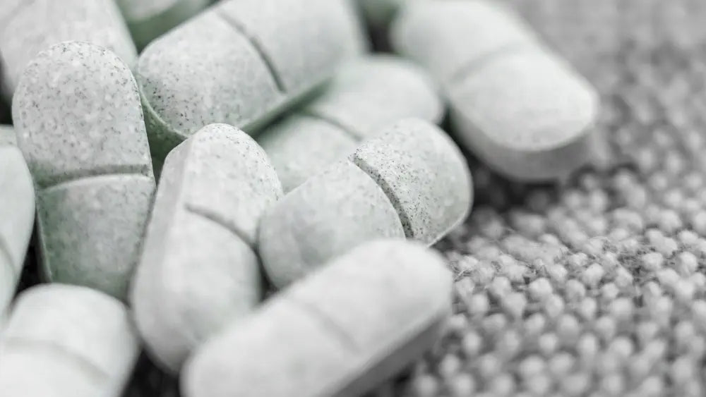 Unbranded 5-HTP supplement bottles and capsules arranged for supplement strength comparison on a warm neutral tabletop.