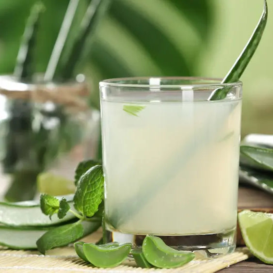 Aloe vera leaf cross-section beside neutral juice bottles and an ingredient panel for comparing inner leaf and whole leaf labels