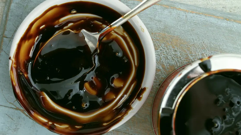 Regular molasses and blackstrap molasses beside cookie dough on a New Zealand home-baking bench