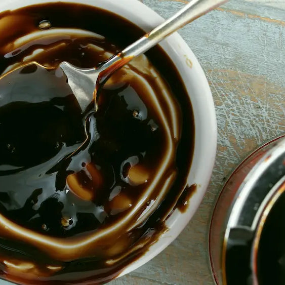 Regular molasses and blackstrap molasses beside cookie dough on a New Zealand home-baking bench