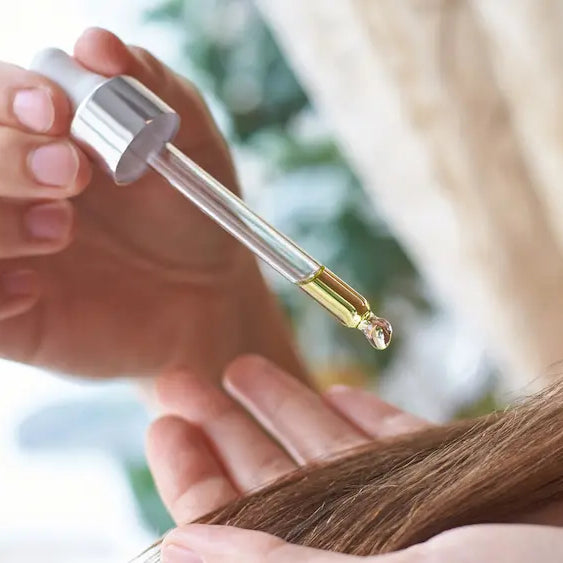 Castor oil beside a lighter carrier oil showing neat use for hair ends and blended use for larger skin areas