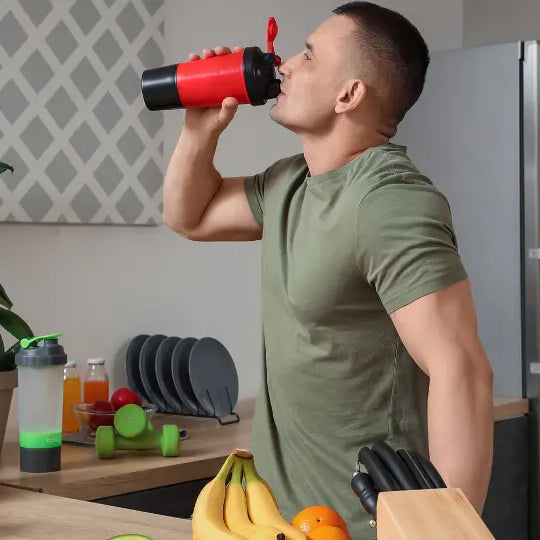 Protein powder beside a shaker, breakfast smoothie and bowl of oats in a bright New Zealand kitchen