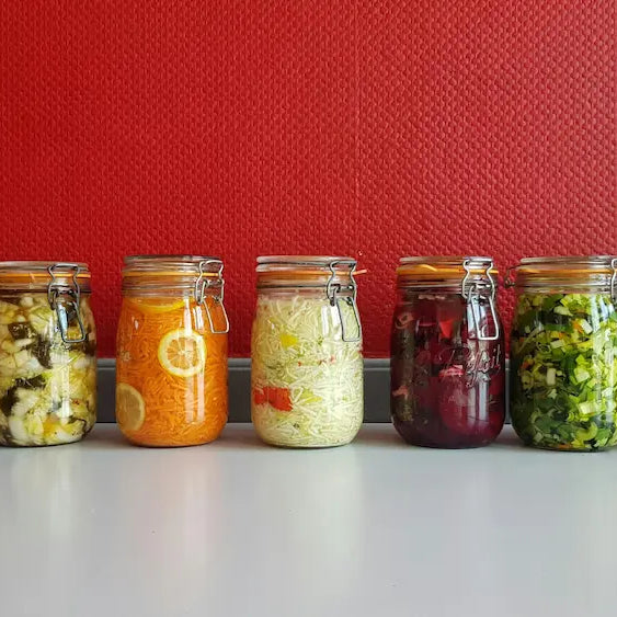 Person checking the label on a dairy-free probiotic beside a probiotic powder in a bright New Zealand home setting