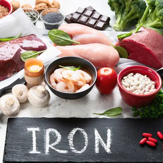Iron supplement capsules beside a neutral bottle and ingredient label concept, illustrating a comparison of iron bisglycinate and ferrous sulphate.