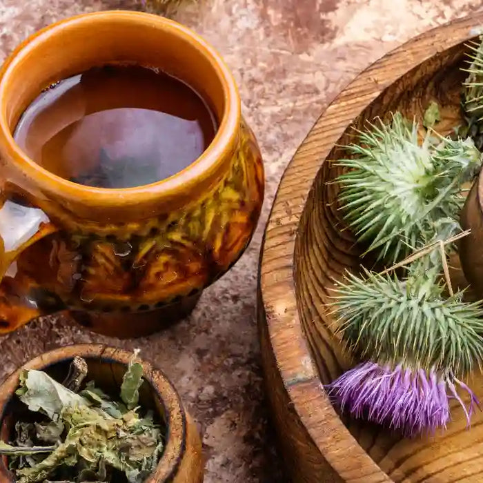 Milk thistle flowers, seeds and supplement capsules arranged for thoughtful product comparison