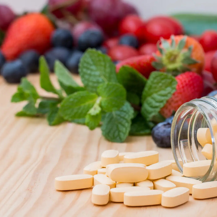 Supplement bottles turned to ingredient panels beside a handwritten vitamin stack audit on a bright New Zealand kitchen bench