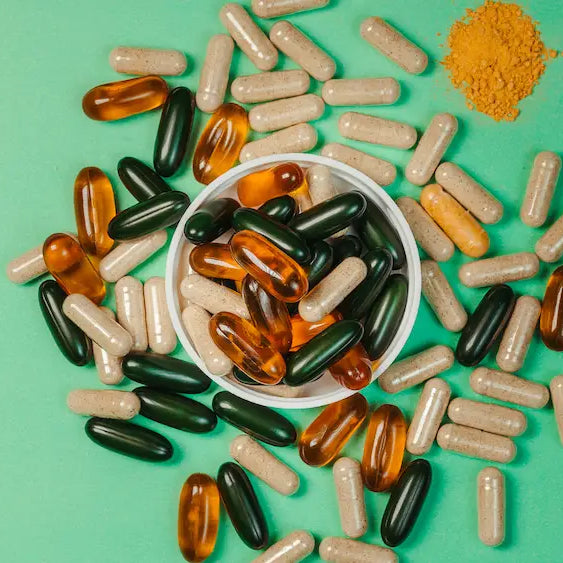 Mushroom capsules, loose powder, liquid extract and gummies on a natural wellness worktop