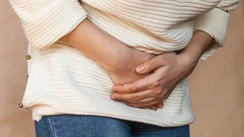 Person comparing probiotic labels while considering a probiotic for bloating in New Zealand