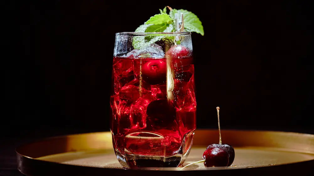 Sleepy Girl Mocktail NZ with deep red cherry drink, sparkling water bubbles and dark cherries