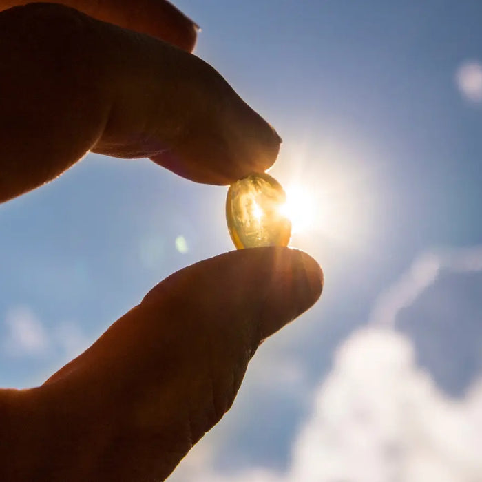 Vitamin D3 and D3 K2 supplement options on a clean bench with soft sunshine