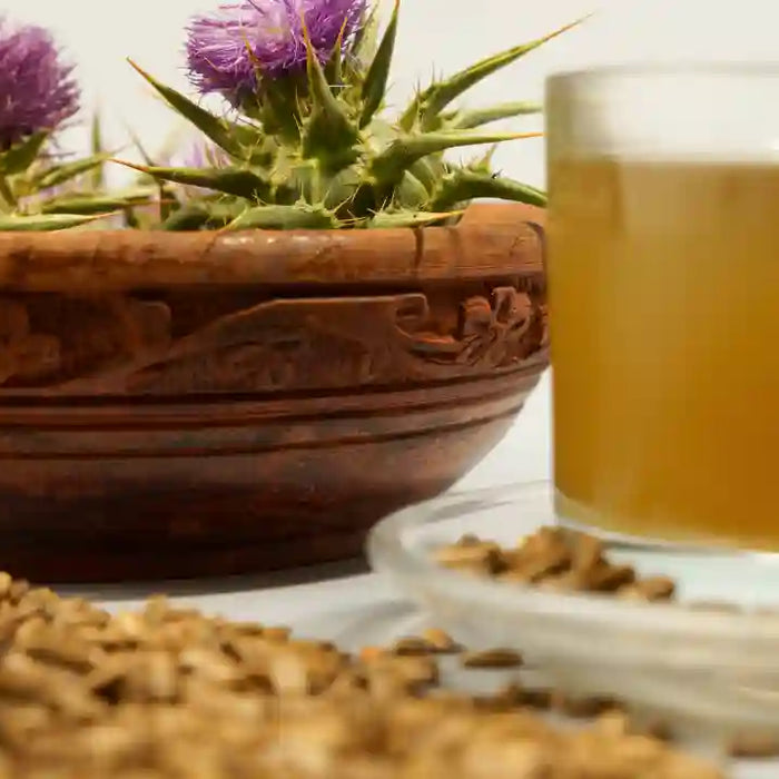 Milk thistle flowers beside a natural-health supplement bottle representing a milk thistle and NAC formula.